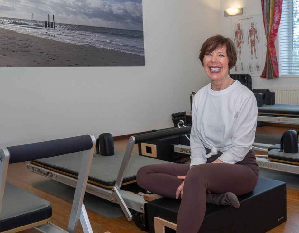Jolanda Cinjee lachend tussen de reformers in haar studio