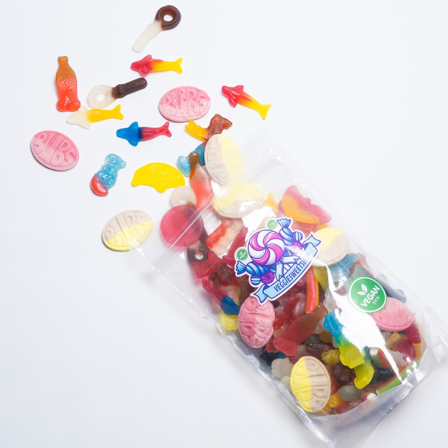 Open zak veggie snoep met uitgestrooide snoepjes op witte achtergrond