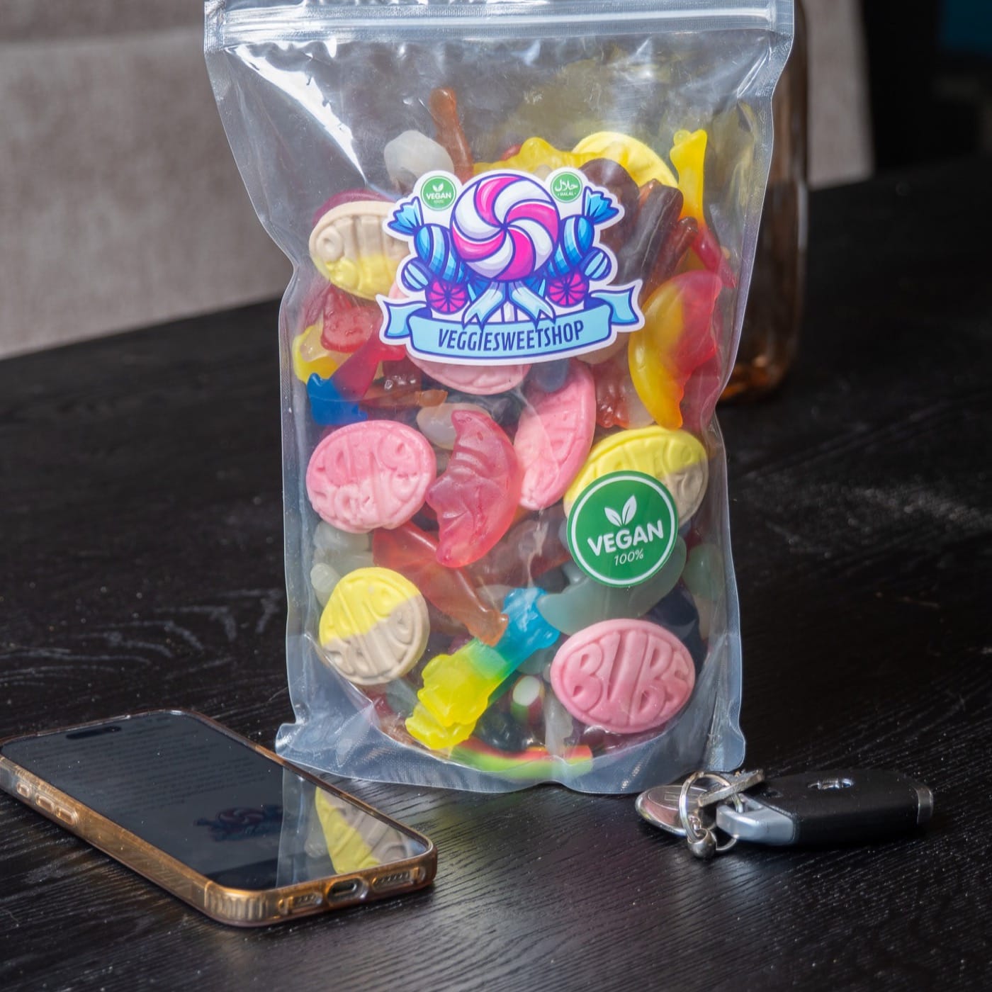 Zak veggie snoep op tafel, sfeerfoto met telefoon en sleutels
