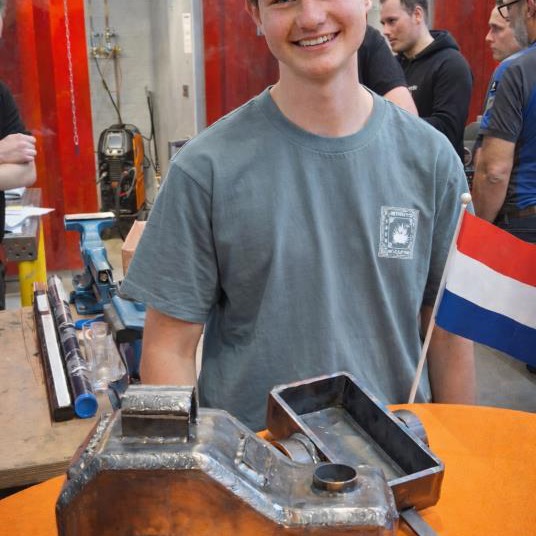 Lachende leerling van STO Zoetermeer met zijn zelfgelaste werkstuk